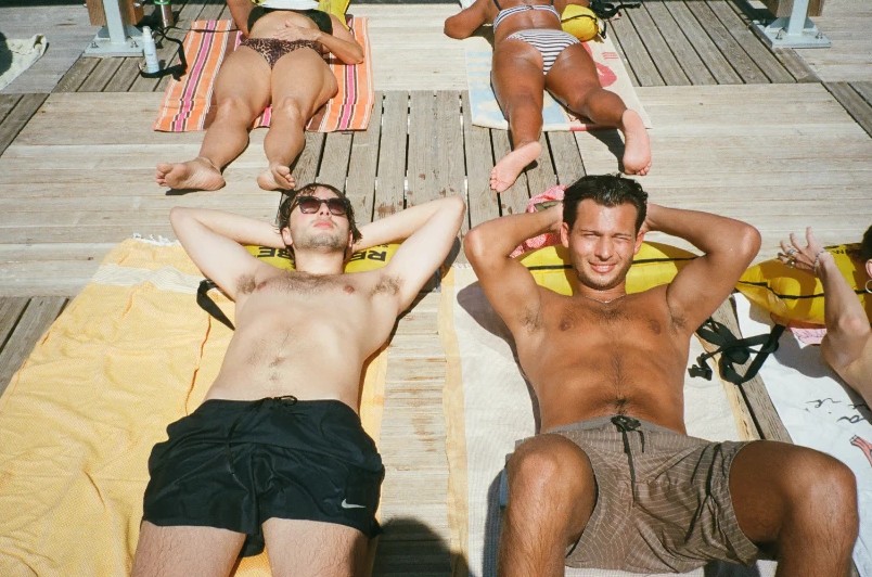 Two friends sunbathing on a wooden deck, on Ultramax 400 film