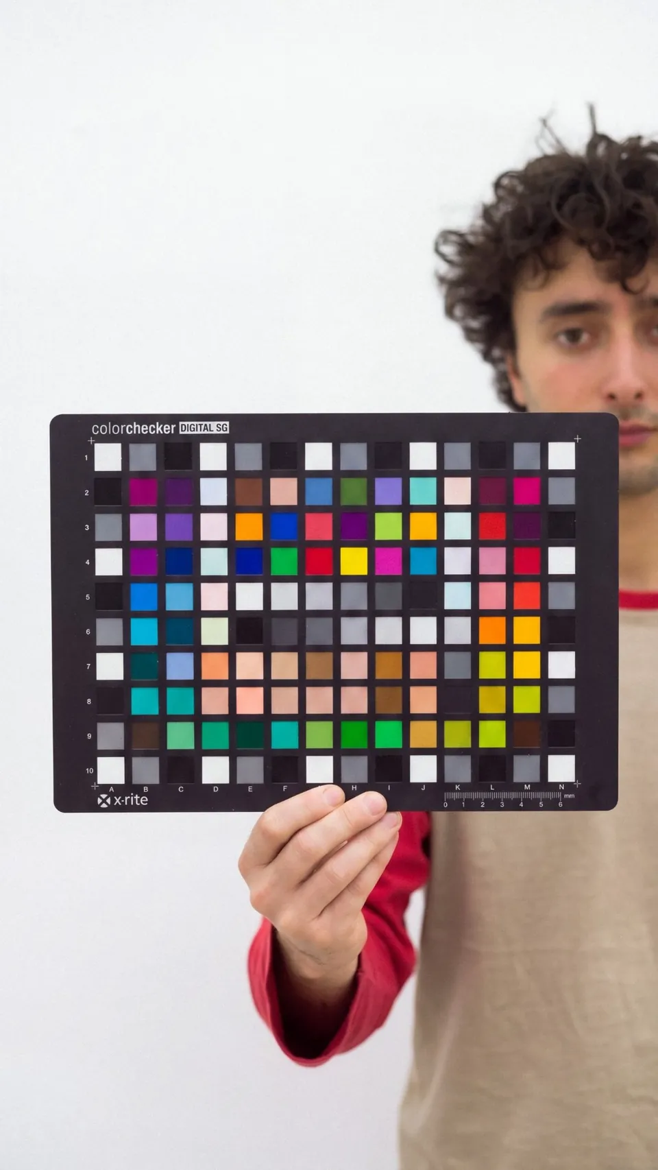 Holding a ColorChecker Digital SG chart, the reference every profile is measured against